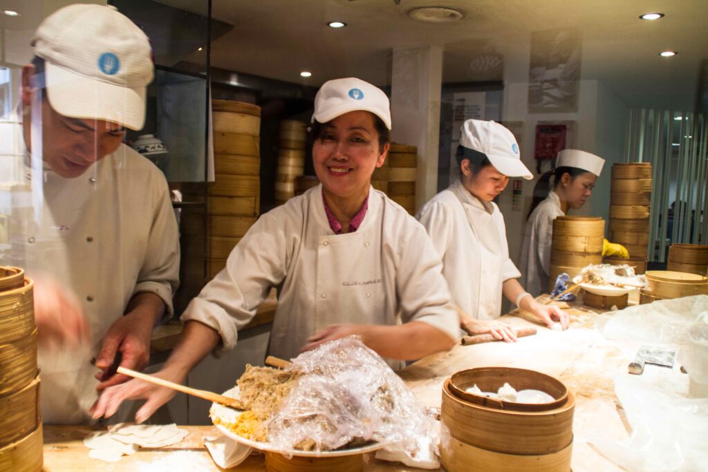 Cooks folding dumplings in a restaurant kitchen