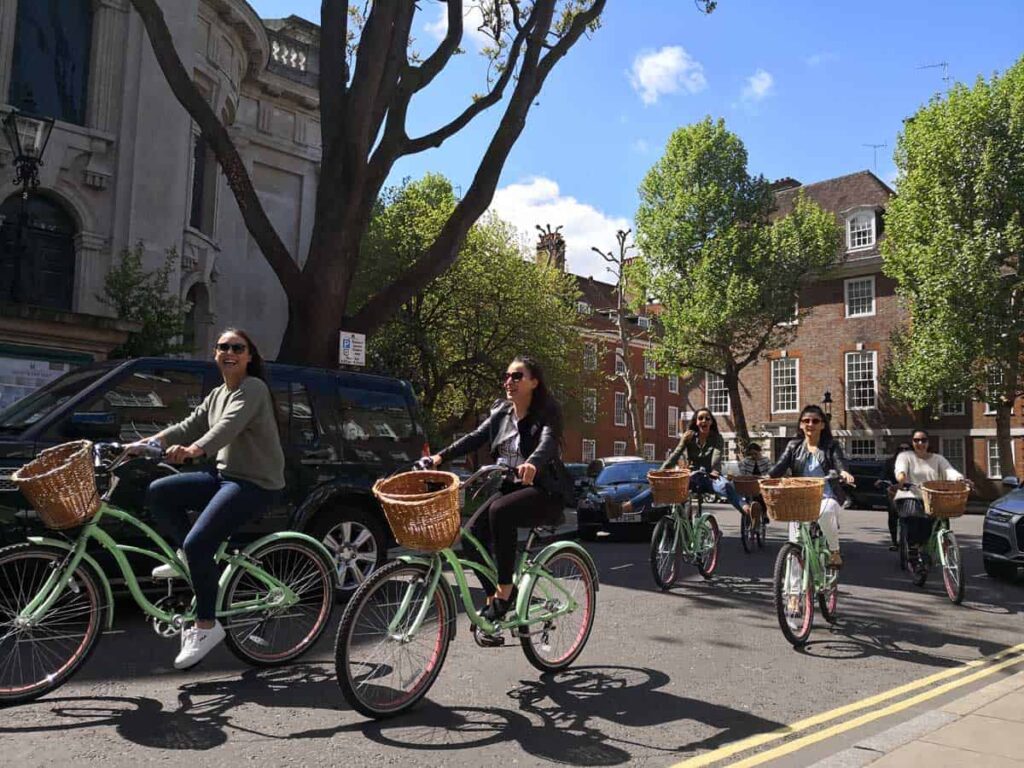 A London bike tours group cycle along a street