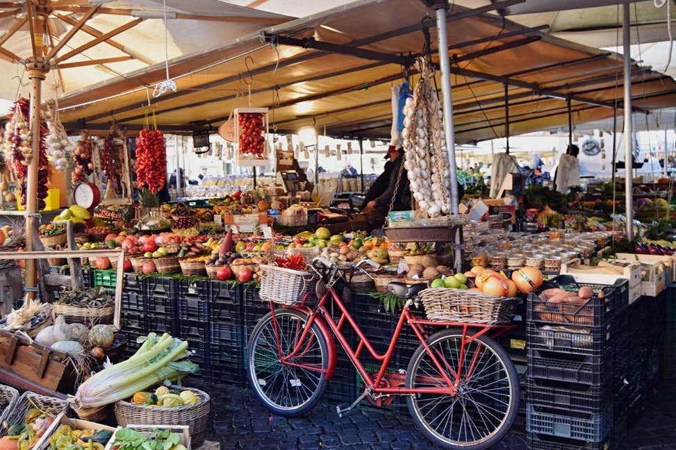 Bicycle leaning against a stand in an open air artisan food market. an Francisco bike Tours