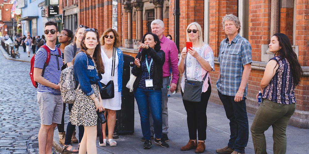 Tour guide leading a group outside on the streets of Dublin.