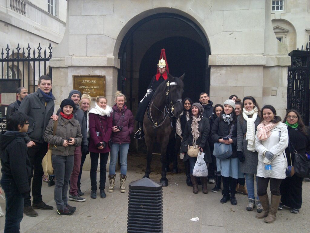 A London food tours group poses in front of Buckingham Palace guard