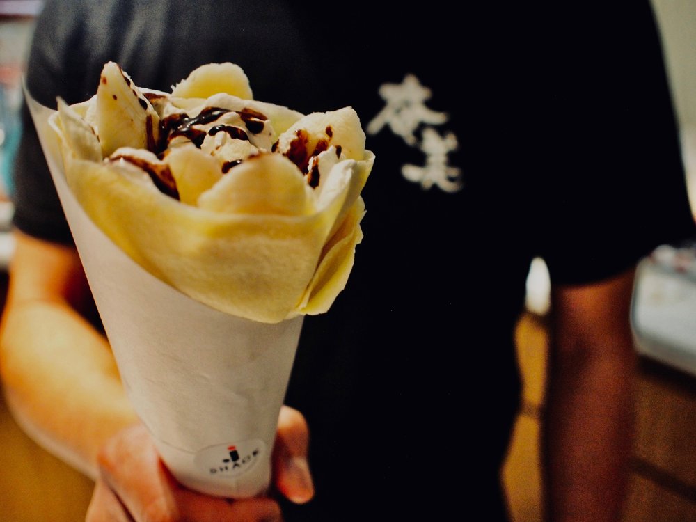 Close up shot of a Japanese desert crepe held by an employee