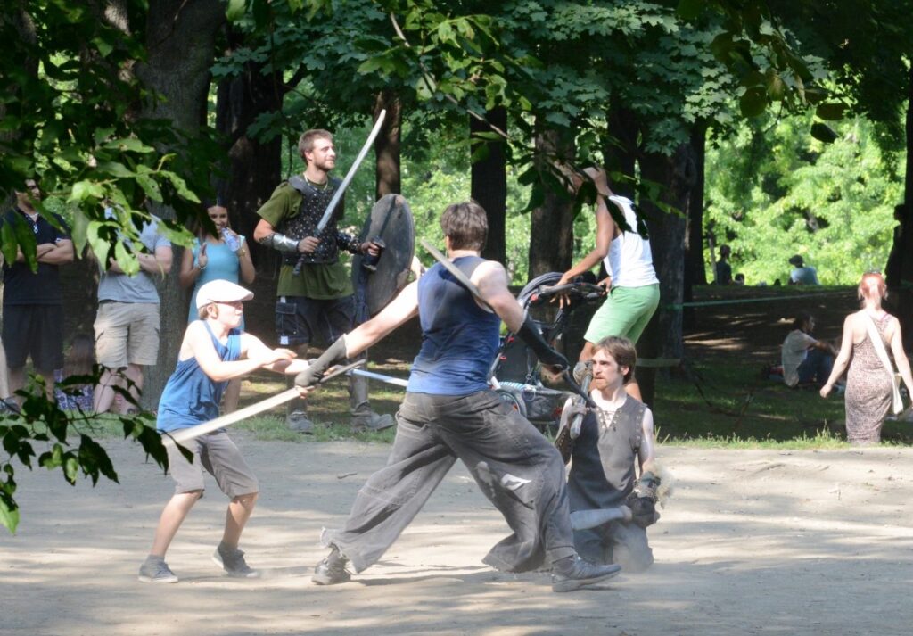 people fighting with foam swords in forest