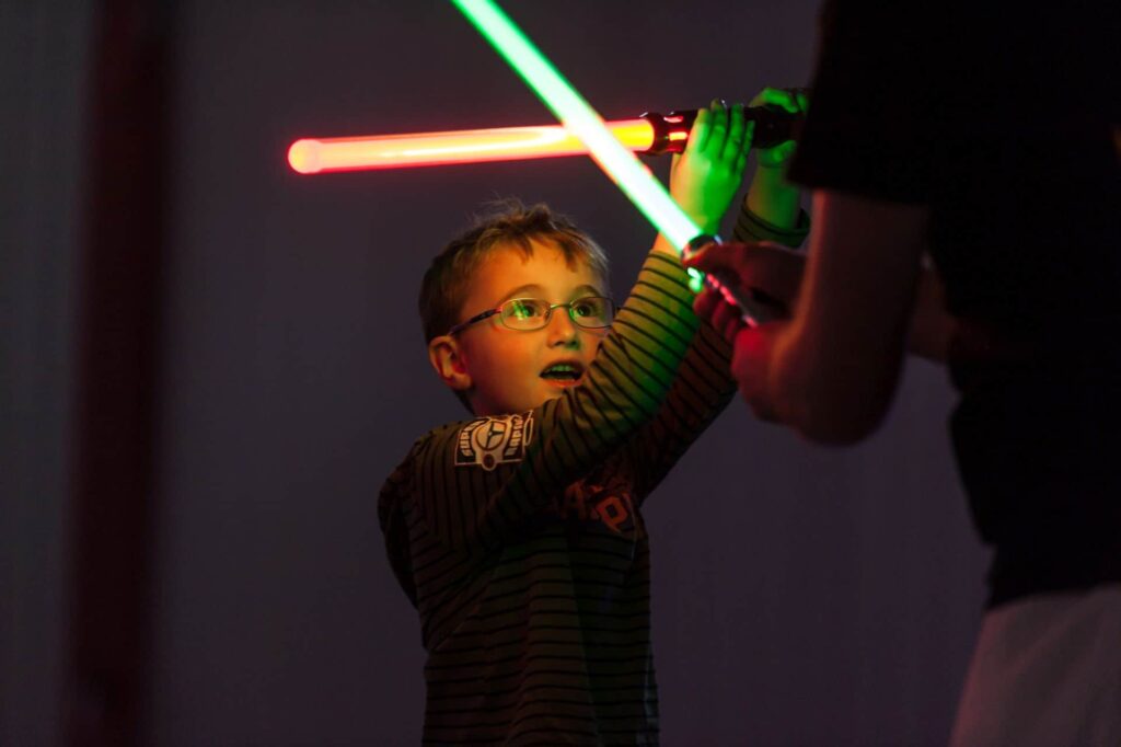 young boy fighting with light saber at force academy