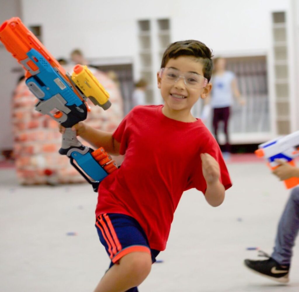 A kid running with a nerf gun