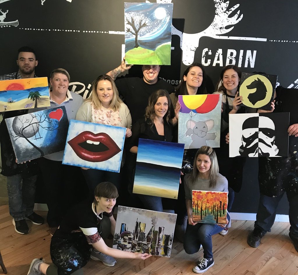 group posing with their canvases at paint cabin toronto