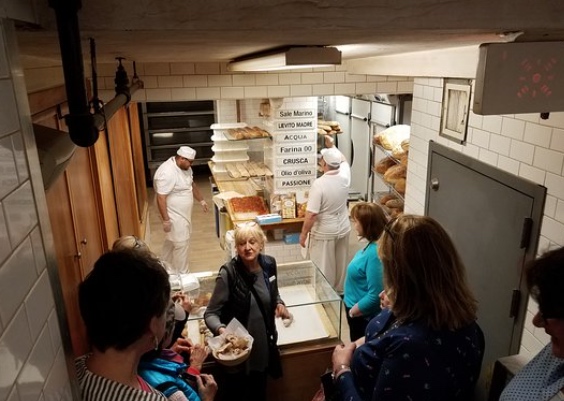 5 customers in front of the tour guide in a bakery.