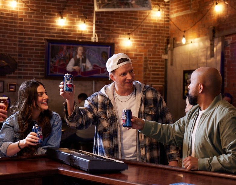 3 people cheering holding a drink